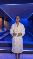 Elisa, présentatrice virtuelle de Calm Spa, en peignoir devant la piscine